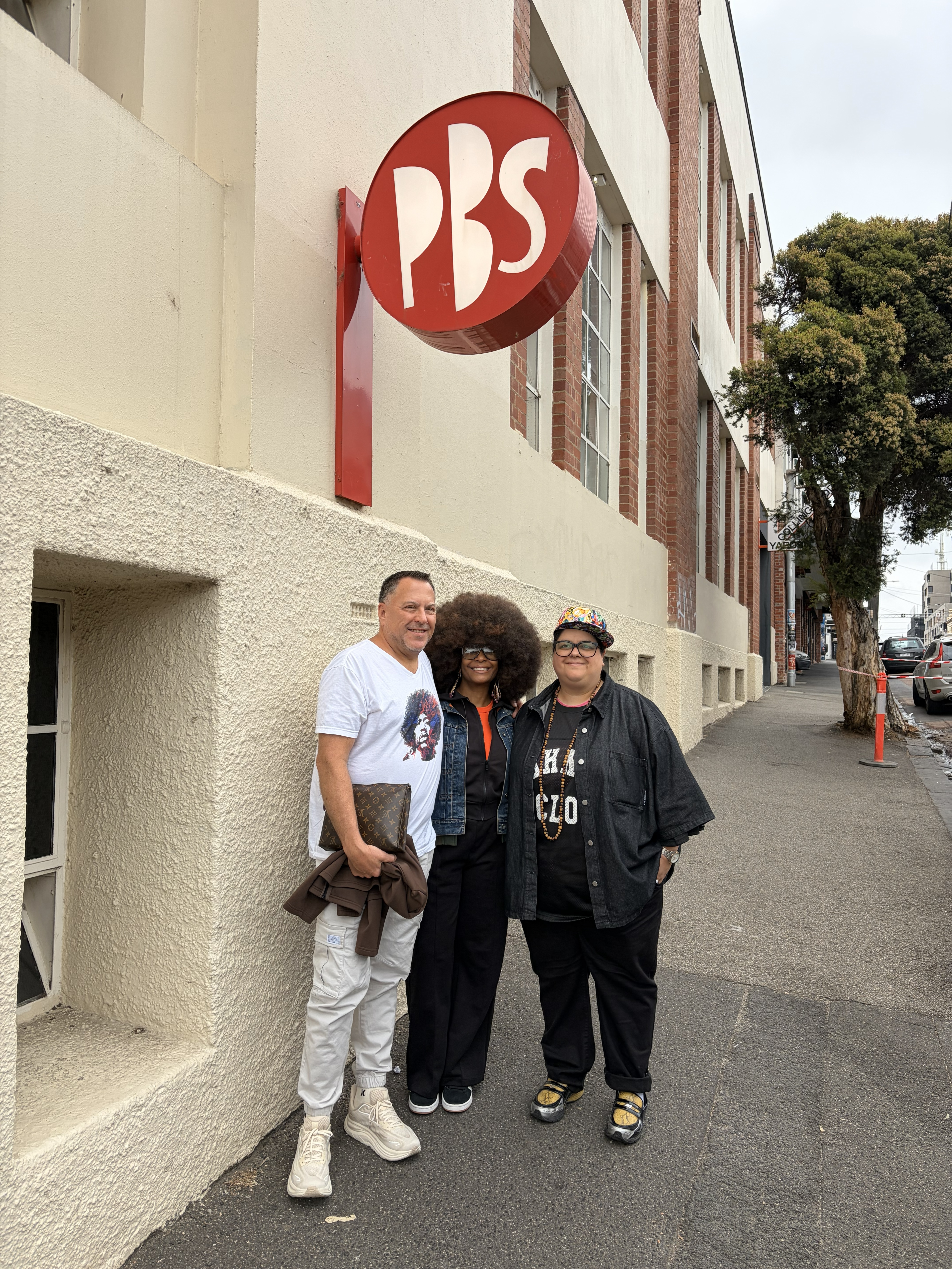 Chris Parks, Vivian Sessoms with Mz Rizk under the PBS Sign on Johnston Street